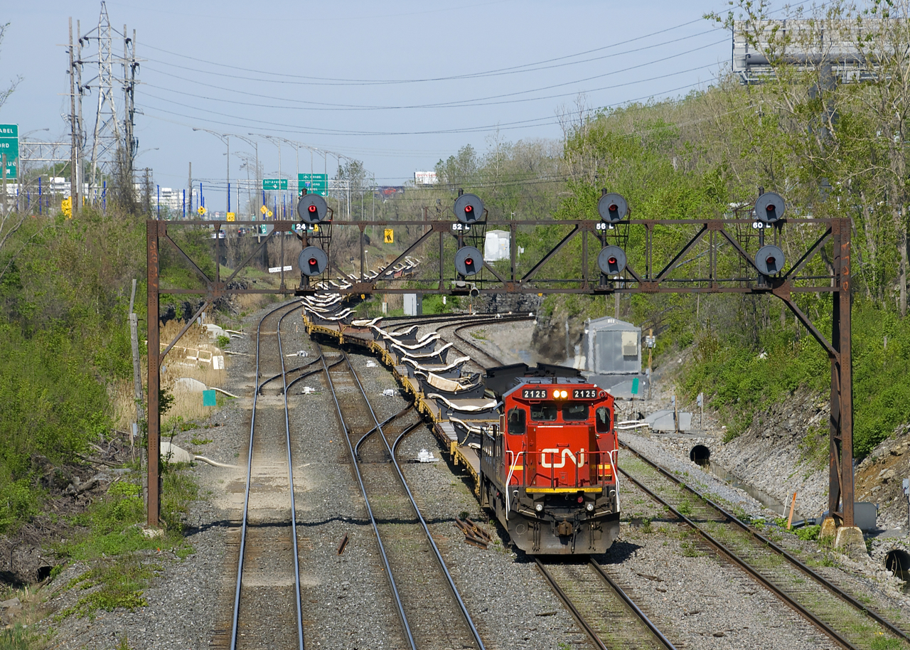 With CN 310 stopped on the north track up ahead at Turcot Ouest to change crews, CN X308 is crossing from the north to the freight track at Ballantyne (it will change crews there as well). CN 2125 is the sole power on this train of empty flats, heading back to the QGRY for more windmill towers.