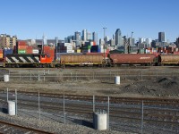 CN 9547 is set up long hood forward as it switches grain cars in the shadow of downtown Montreal.
