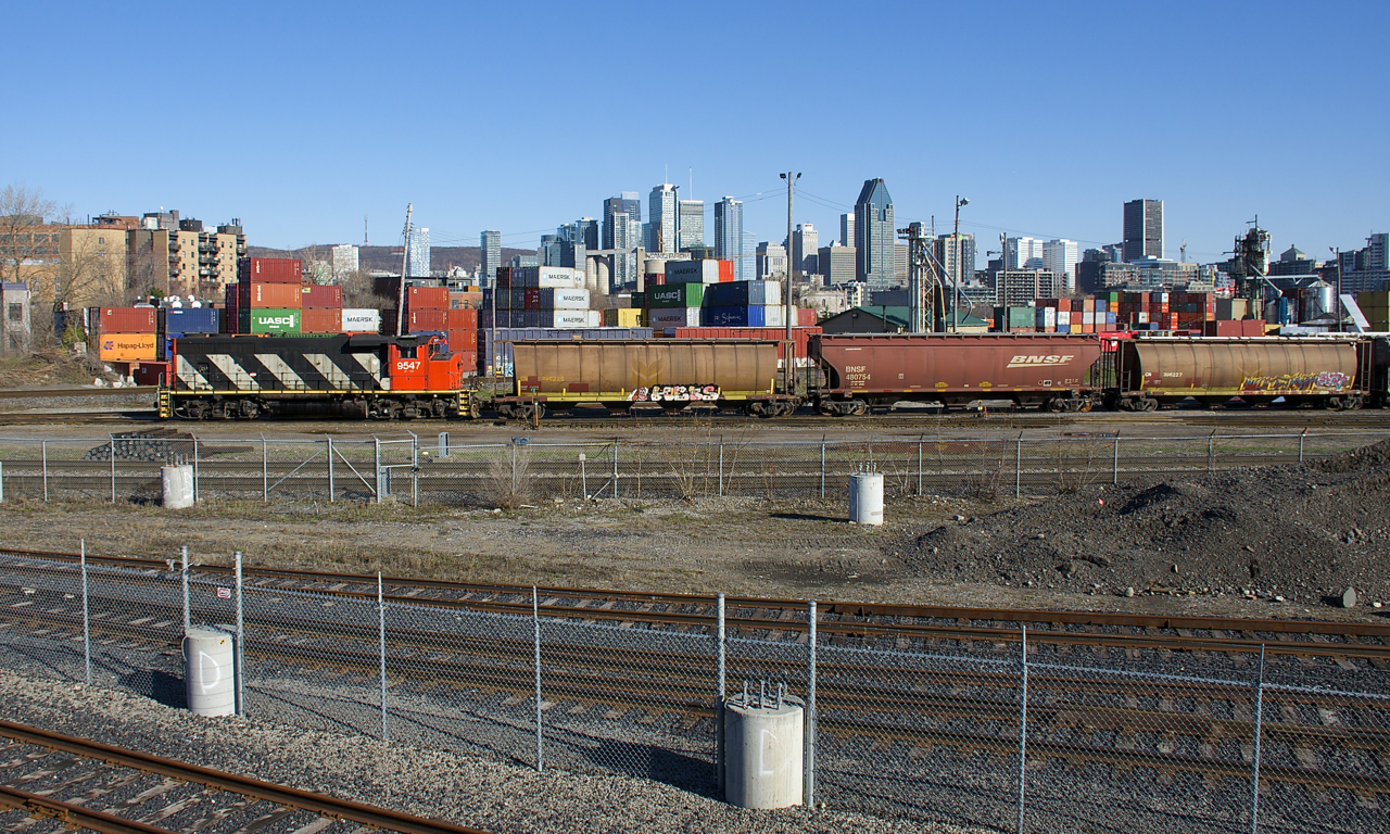 CN 9547 is set up long hood forward as it switches grain cars in the shadow of downtown Montreal.