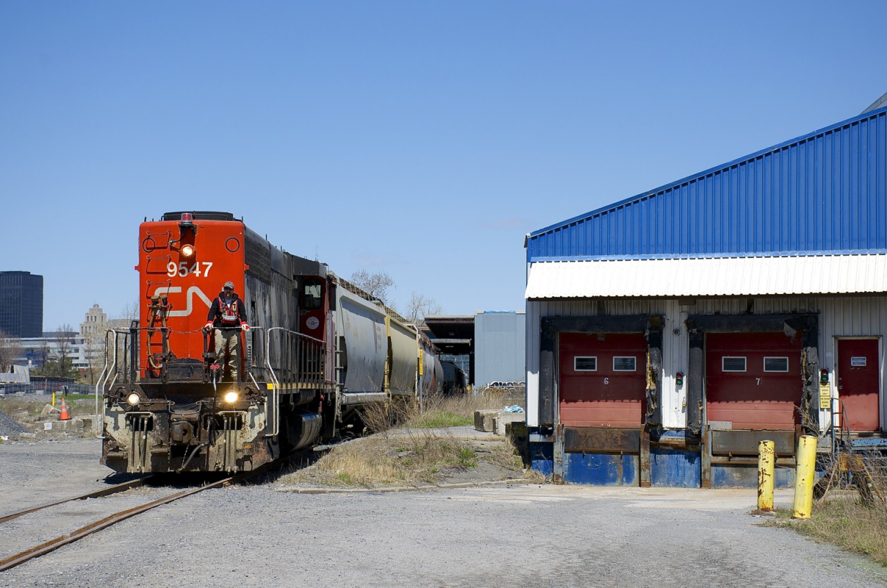The Pointe St-Charles Switcher is leaving the P&H mill with six grain empties with CN 9547 running long hood forward as it approaches the Bridge Street crossing.
