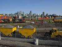 A pair of GP9's (CN 7075 & CN 7229) idle in CN's Pointe St-Charles Yard as two ballast cars are being pushed by a speed swing in the parallel EXO yard. In the distance at right, VIA 22 heads towards Central Station.