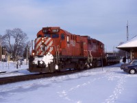 The sun is trying to break through the overcast winter sky as empty “sprint” train 141 storms past the old station at Galt after dropping its loaded frame flats at the GM plant in Oshawa earlier in the day. Originally mated to a GP9U, RS18 Control Cab 1117 is now seem mated to a more powerful GP38 3057.