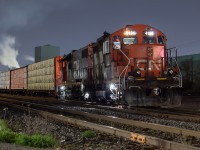 I have been having a lot of fun recently experimenting with night shots. It is fun to try something new. Here, 555 is pictured setting off the usual big string of gons, coils, and bulkheads at Parkdale Yard. The three loaded centrebeams on the head end are for Turkstra Lumber on Green Road. After the set off, they would proceed on the north track past Millen, and shove back onto the south track and into Turkstra. <br><br> It would appear that 555 is based out of Hamilton now - no longer calling Aldershot its home. 555 is a night job, and is using one of the yard sets at Stuart while the 2300 yard job uses the other. When 555 was transitioned to Hamilton at the beginning of May, they originally had a three pack of GP9s - 4131, 7022, and 7038. The other power set in the yard at the time was 1444 and 4704. On Saturday, 1444 encountered some issues and has since been sent back to Mac, leaving the two sets to be 4131 and 4704, and 7022 and 7038. The remote units on each are 4704 and 7022. Time will tell if they bring a third unit for the one set, as 555 has traditionally been a three unit job.