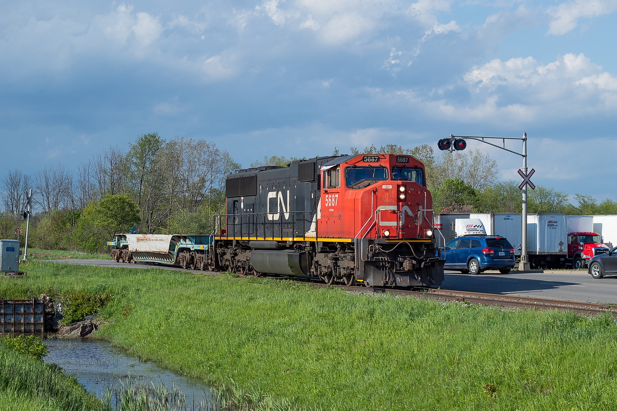 Under stormy skies to the north, 562 makes its way south down the Humberstone Spur in Port Colborne. They lifted the empty dimensional flat from Southern Yard, after returning from a transfer run to Trillium over at Feeder. I was a little confused about the empty dimensional flat given that the Humberstone's sole customer, Vale, only receives tanks. But you never know what is inside a plant like that, so I didn't think too hard about it. I soon found out that the flat isn't for Vale however; it is for JTL Integrated Machines which is just down the street. A 260,000 pound component of a metal shredder will be trucked down the street and loaded by two cranes onto the flat. In the end, it is destined for Minnesota. The remaining components will make their way there by truck.