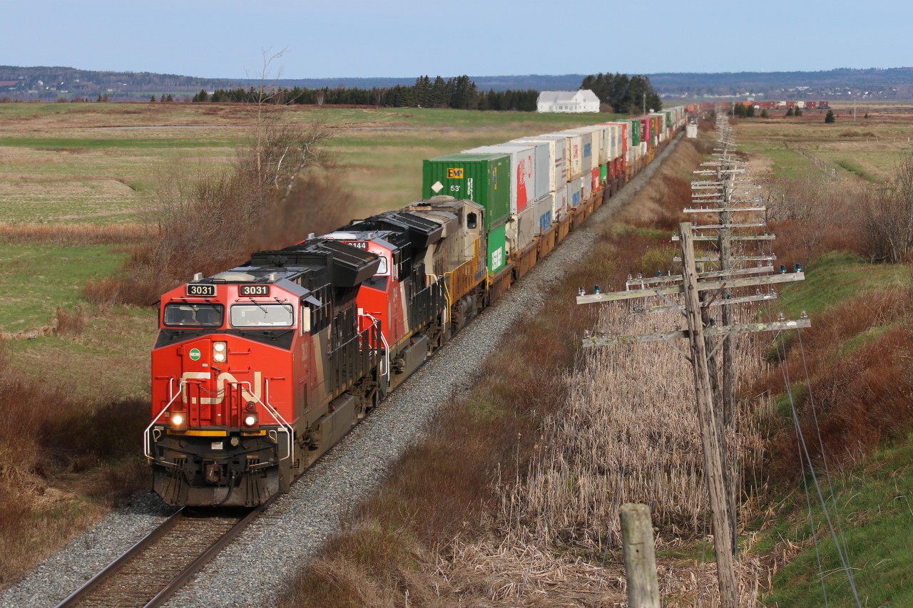 CN Q120 is seen in its entirety crossing from NB to NS with 3031 on the point leading 464 axles to the Port of Halifax