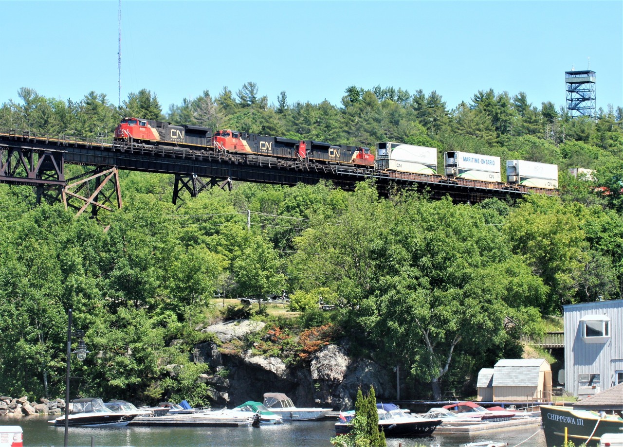 CN train 101 with 8024, 2318 and 8912 are northbound on the DRZ (Directional Running Zone) as they roll under historic Tower Hill and onto the 1695-foot Canadian Pacific trestle over the Seguin River and the busy Parry Sound harbour.
