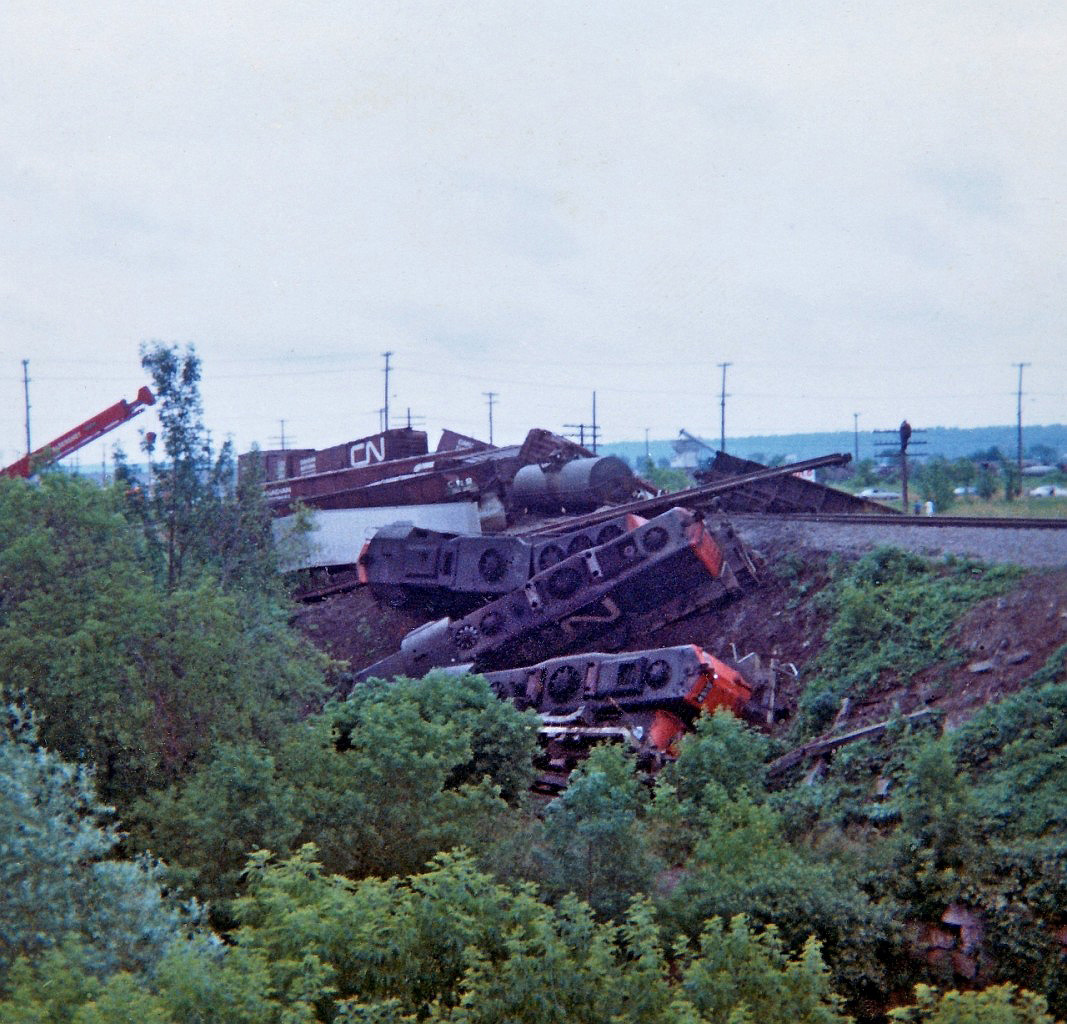 A bad day for trains and another Kodak Instamatic moment almost 51 years ago. West bound train on the CN Grimsby sub hit a low boy trailer on the crossing at Nash Road in the east end of Hamilton. It was quite a derailment, the crew suffered serious injuries and fortunately non life threatening. It must have been quite a ride down the embankment. I'm not sure which unit was leading, on the bottom of the pile was CN 3641, 4515, 4578 with 4016 resting on the edge of the large concrete bridge over a creek.
This image is a scan of a print that I took that day. Unfortunately the photo is starting to deteriorate and did  not scan well