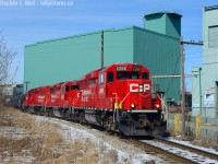 Tracks everywhere - where I'm standing I'm surrounded by railways you almost think you can't go wrong in Hamilton, but once you dig the locals in this part of town a bit deeper you realise it's not exactly the best place to be for any extended period of time. So explain why I keep going back? Along the former TH&B Belt line, for an industrial Branchline it's kind of neat - how many spurs that weren't part of a mainline have telegraph lines like this one does? Rounding Dofasco's Operating Services building the boys are heading back to Kinnear with their switching work completed in North Hamilton.  A nice Kodachrome sky, a light dusting of snow to cover Hamilton's grime and low winter sun to complete the scene. <br><br>p.S - what's that thing to the right facing the tracks? Any relevance to railways?