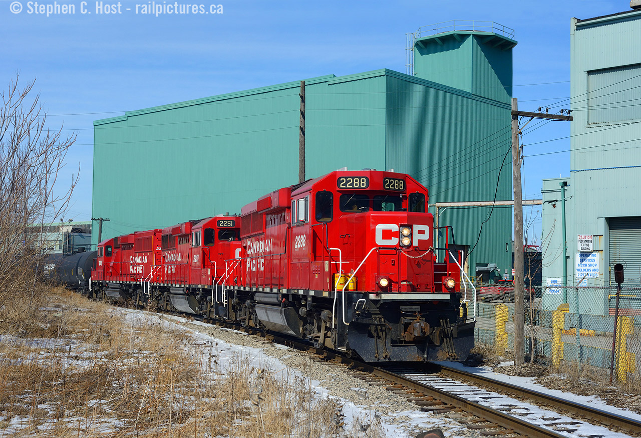 Tracks everywhere - where I'm standing I'm surrounded by railways you almost think you can't go wrong in Hamilton, but once you dig the locals in this part of town a bit deeper you realise it's not exactly the best place to be for any extended period of time. So explain why I keep going back? Along the former TH&B Belt line, for an industrial Branchline it's kind of neat - how many spurs that weren't part of a mainline have telegraph lines like this one does? Rounding Dofasco's Operating Services building the boys are heading back to Kinnear with their switching work completed in North Hamilton.  A nice Kodachrome sky, a light dusting of snow to cover Hamilton's grime and low winter sun to complete the scene.