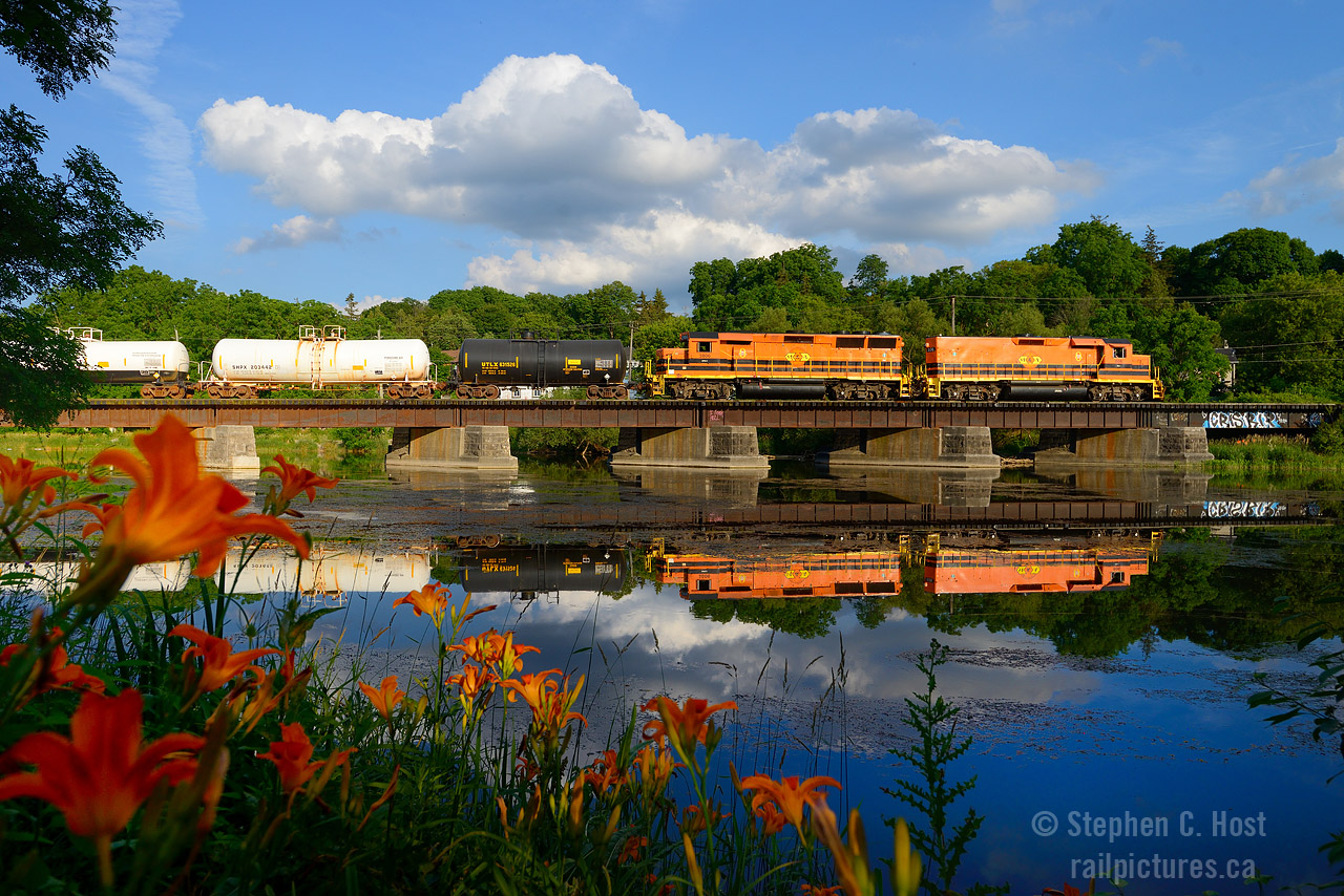 Orange daylilies match the G&W livery as GEXR 582 heads for home crossing the Speed River at Hespeler on a warm, humid summer day. The mother/slug set was assigned to the train for a while during this time period. Really enjoyed the flared radiators of the 3806.