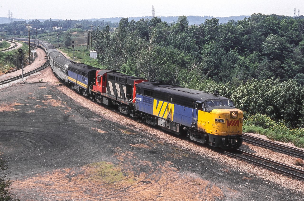 VIA 6761, CN 3115, and VIA 6871 are eastbound through Hamilton West in Hamilton, Ontario.