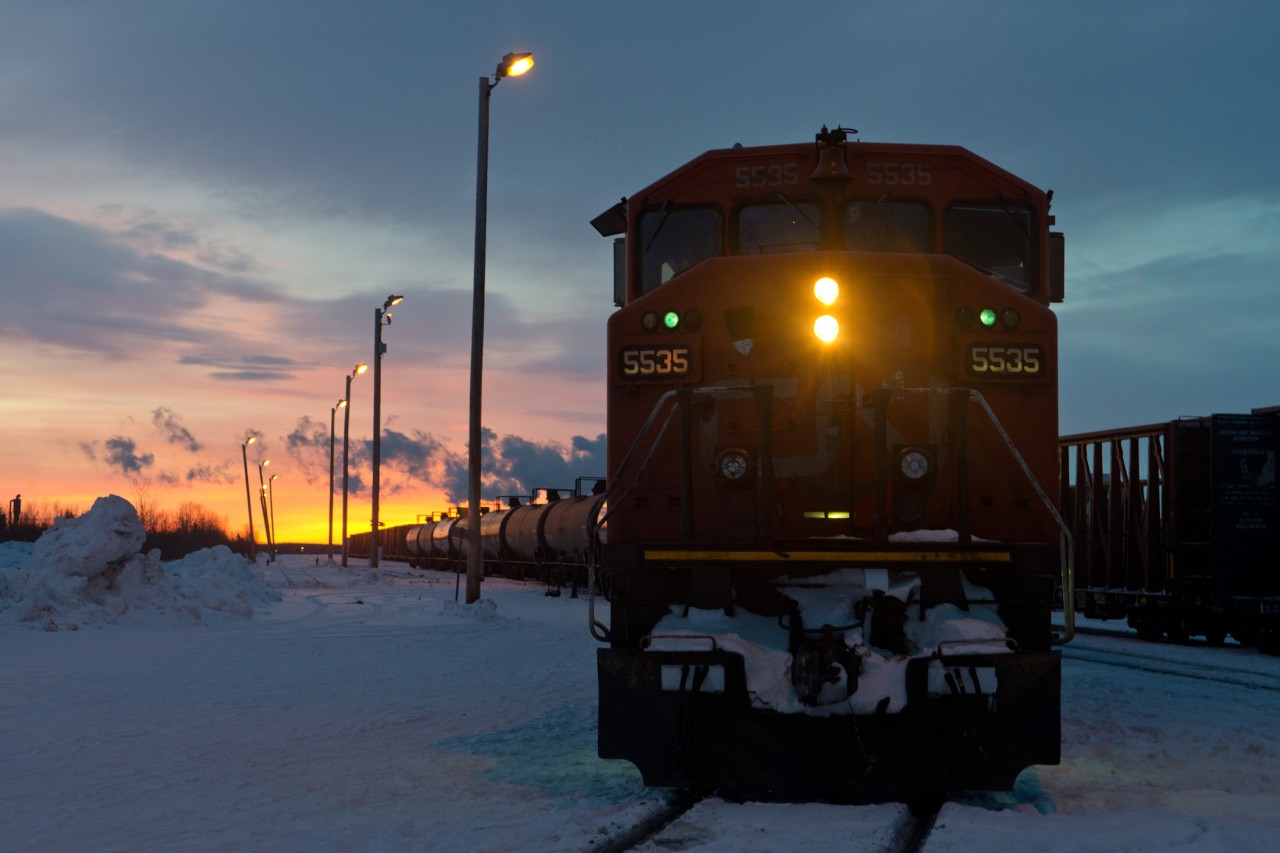 CN train 479 is seen here nosed onto the Fort Nelson Extension with a short train of fuel to bring to the community of Fort Nelson, some 250 miles north. The "old main" can be seen to the right and ends in about 35 car lengths. At one point this was the northern most point on the PGE until the early 1970's when the railway was extended to Fort Nelson. It's just past 0900 and the sun is only beginning to rise. The old station building once sat somewhere around where that pile of snow to the left is.