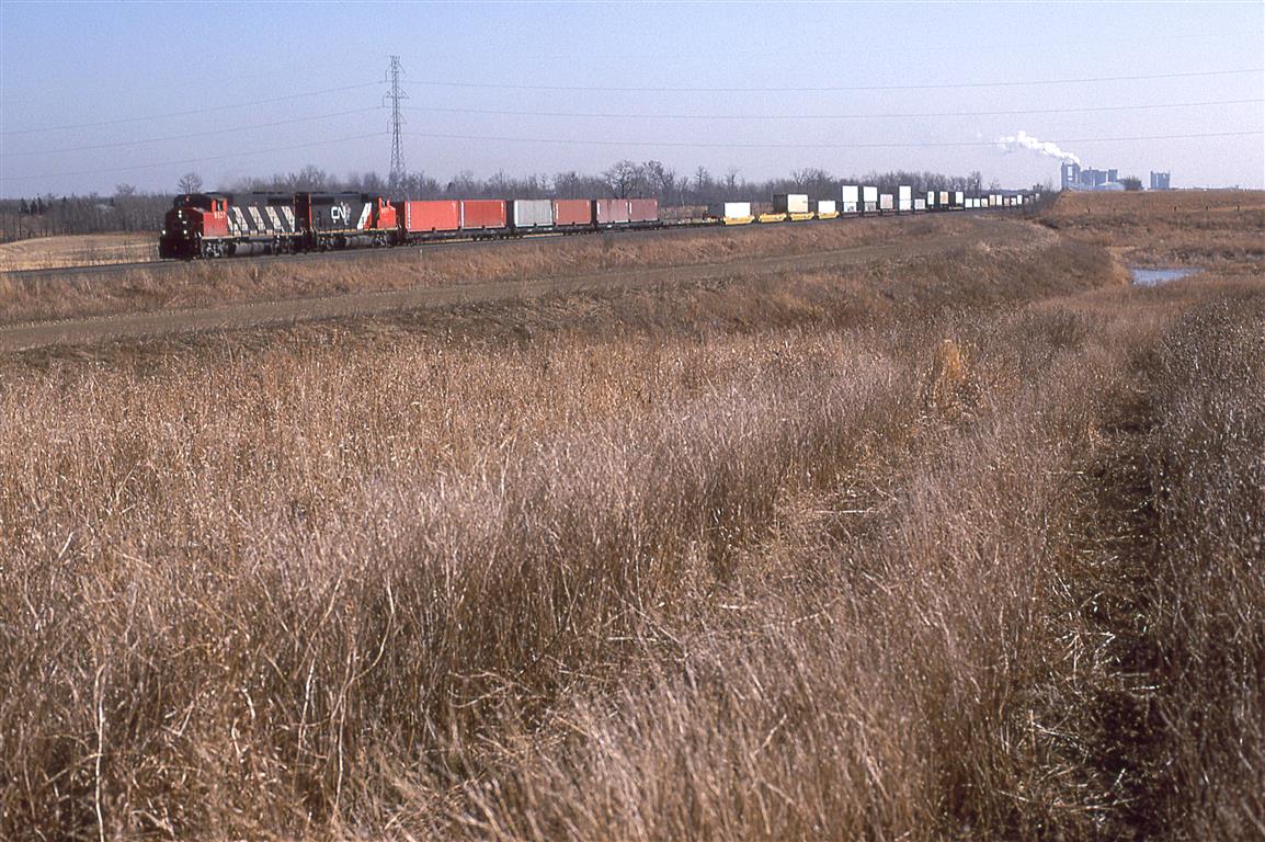 The first westbound train to leave Edmonton after the strike of '95 was this intermodal train (COFC, double stack and TOFC). I think that it parked in Walker Yard during the strike. I do not remember seeing it in Bissell Yard.
The curved graded ROW will soon host a shoe-fly for these tracks as the City/Province finally begins the project of Highway 216. a RR bridge and highway underpass will eventually grace this location.