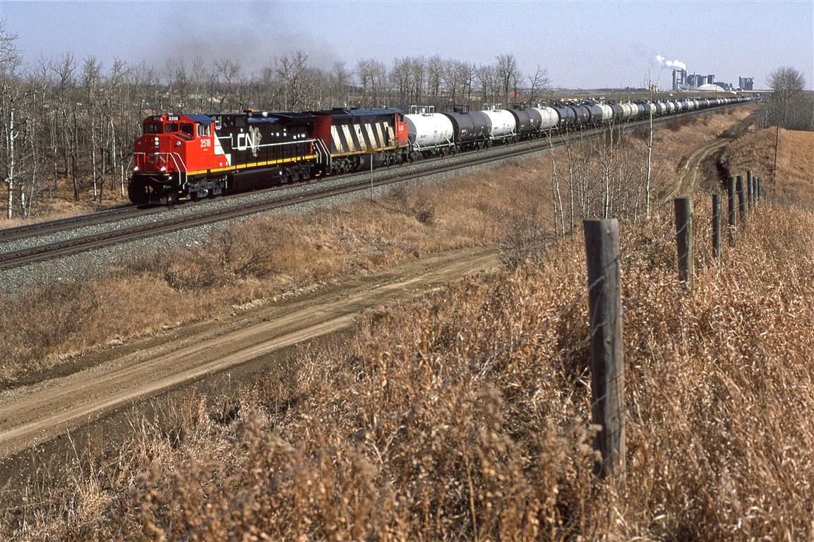 The second westbound out of Edmonton immediately after the strike of '95 was the highly lucrative chemical products train 411. Edmonton's chemical companies were steamed about the strike. I don't know if it is just a coincidence, but it is led by CN's newest power.
The steam in the background is  from Inland Cement's facility, not Dow Canada's HQ.