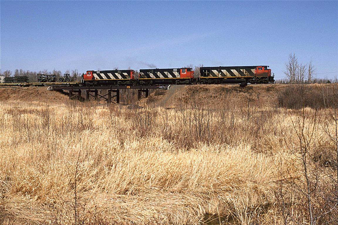 I do not recall if I had a head's up on this train, or if I was just lucky (although, I think that it was the latter). Seeing MLW units in Edmonton was as rare as hen's teeth.
In tow are cars carrying military equipment, in all likelihood, destined for Waingwright's base.