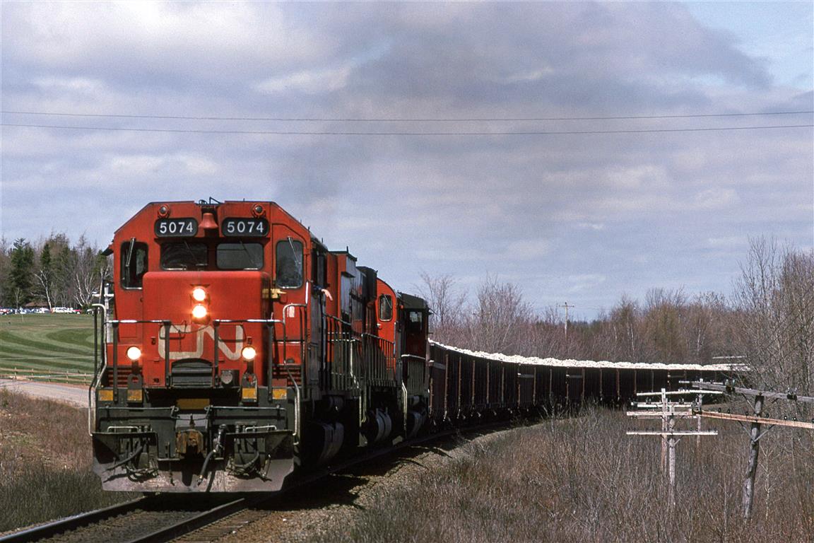 After showing off our kid to the in-laws in the Ottawa area, we flew to my folk's place in Halifax. There was a little time for train watching. 
By 1995, I guess the MLW's were not the dominating presence that they used to be. Here a big MLW is sandwiched by EMD products. At least the lead unit was not a wide nose.