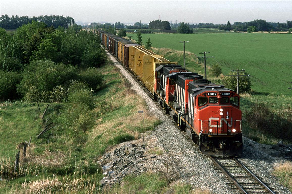 With an extra car in the driveway (we purchased a 4 door car with the arrival of our second child, and were in the process of selling our older car), I had access to wheels. Unfortunately, I could not get a drivers license on account of my vision. This is where Fred Clark came in. He, too came from a one vehicle family, and his wife needed to to get to her office. With the academic term at U of A closing, Fred had time for some fun. We took the car out to see what we could find. #579, running up the Cornodado Sub seemed like a good candidate to chase.
Here it is, just past St Paul Junction, now fully on the Coronado Sub, about to duck under Highway 15.
Back then, at 0800 hrs, the dispatchers would transmit a lineup for each subdivision.