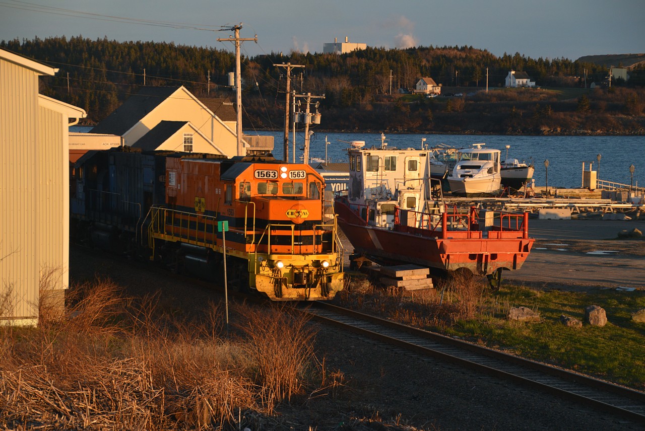 Very last rays of a beautiful evening. CBNS 1563 and 1504 had worked over at Port Tupper, servicing the huge pulp and paper mill (far background)and the power had run around the train in order to head back to the NS mainland. I waited. Much to my disappointment, the train stopped at the station and after a long wait I gave up thinking they would not be moving again until after dark. But no. I got back to the motel and then heard the horn. They were finally on the move. So I ran out the motel door and shot this from the deck. Interesting local theme to the photo; Canso strait in background, as well as the community of Port Tupper. Sitting up on blocks is a standard fishing boat being overhauled, and I caught the CBNS power just about to pass by. The 'station' is about 300 ft to the left, out of sight.
The huge paper mill as well as the Port Tupper generating station are worked by the CBNS local. Otherwise, that is the extent of the 'action' on Cape Breton. The line north of Port Hawkesbury thru to North Sydney has not seen train service in at least 4 years.  No idea if it will resume any time soon.
CBNS 1563 was the former LLPX 1508. The second unit, 1504 still in LLPX colours and when it goes to the paint shop it should emerge as CBNS 1561, according to the Trackside Guide. Units listed as GP15-1. I'm not familiar with them.
Having really no use for G&W orange, I must admit I really miss the old CBNS Alcos from years gone by.