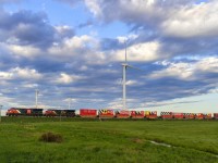 CN eastbound stack train Q120 heads by the turbines at Fort Lawrence, Nova Scotia, with the celebration CN 100 containers near the head end. They are destined for the next show at Halifax, Nova Scotia for next weekend. CN 3191 is also on the head end, sporting the CN 100 scheme. A nice touch. 