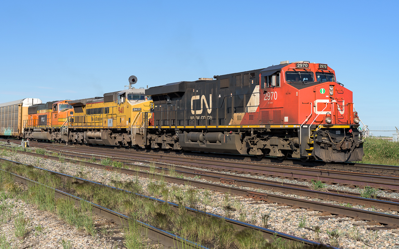 CN 2970, GECX 9411 and PRLX 257 are coming up the hill to Clover Bar with a long train of loaded auto racks.