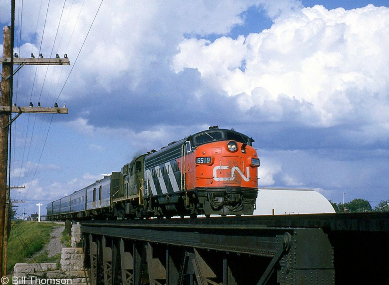 CN train #75 heads westbound behind zebra-striped FP9 6519 and an RS18, crossing the bridge west of Port Credit in September 1964.