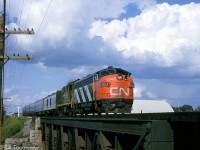 CN train #75 heads westbound behind zebra-striped FP9 6519 and an RS18, crossing the bridge west of Port Credit in September 1964.