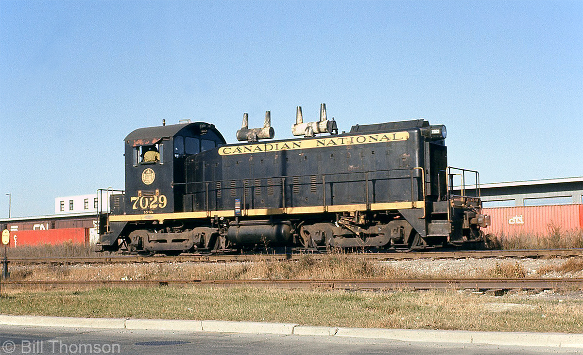 CN SW1200 7029 sits on one of the switching leads along the southeast end of Mimico Yard, parallel to Drummond Street, near one of CN's old LCL/freight sheds.

Outflanked on the roster by the more popular SW1200RS model (that were equipped with road trucks and full numberboards for roadswitcher service), CN did have a handful of "plain" SW9 and SW1200 models built by GMD between 1952 and 1959. As-delivered, they wore the standard CN switcher livery of black with yellow letterbands, as seen here.