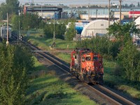 Going over the tracks on the Sherwood Park Fwy., I catch a glimpse of the 7227 sitting down below. They are asking for permission to go through the work area set up for replacing the East Edmonton diamond. In the distance down the tracks you can see the CN Strathcona sign and siding. The track curving off to the right from the mainline (you can see the red target on the switch) is the Strathcona spur. Although still of some length (over 6km's now compared to over 9km's in the past) it serves only a few customers. That is the WC 3027 tucked in behind.