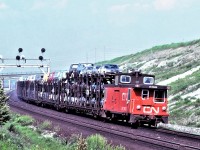 Just over 40 years ago, the west end of an eastbound freight is shown with brakes applied as the unknown train slows for the diamond at Doncaster on CN's York Subdivision. Interesting features in this photo include brake shoe smoke, open bi and tri-level auto racks, and of course the caboose. Also of interest is the railways' ability back then to load trucks on the top deck of tri-levels.