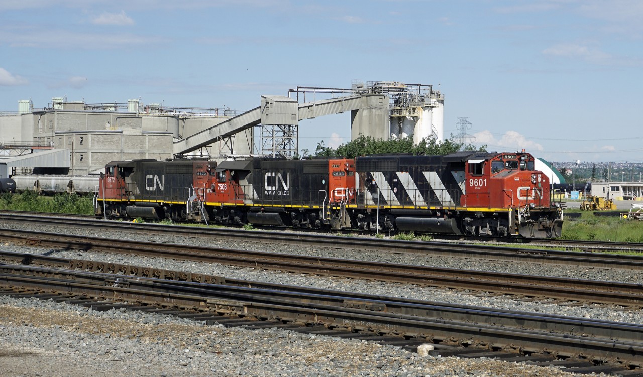 GP40-2s CN 9601 and 9672 bracket SD38-2 CN 7503 as they make a light engine move down the back tracks at Clover Bar Yard