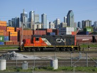 CN 7075 idles in the Pointe St-Charles Yard just before coupling to CN 7229. In the background is the skyline of downtown Montreal.