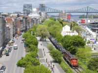A CN transfer is leaving the Port of Montreal with 16 cars as it parallels a bicycle path.