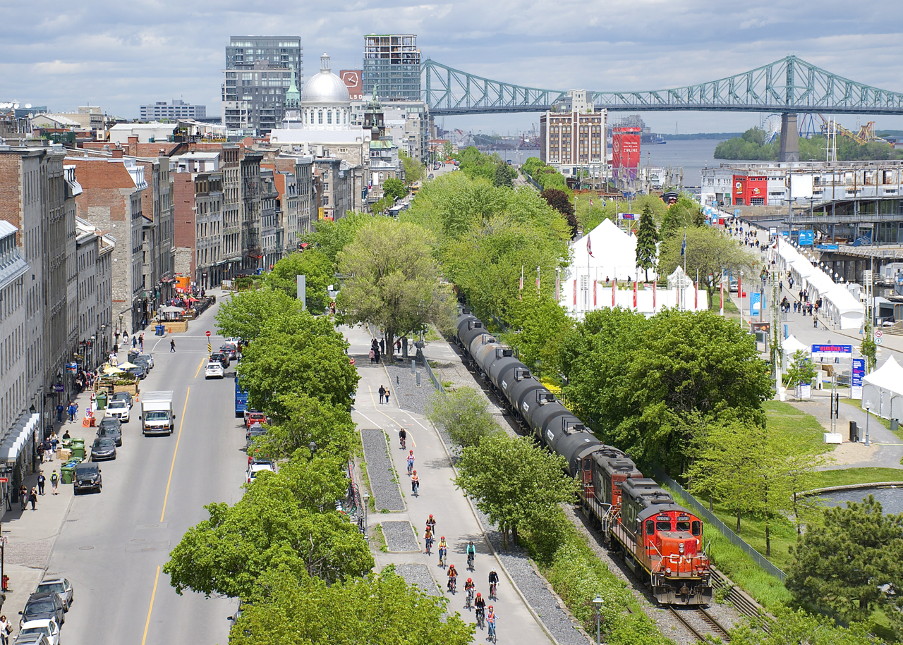 A CN transfer is leaving the Port of Montreal with 16 cars as it parallels a bicycle path.