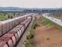 Heading away from the camera, on the CP Hamilton Sub, is CN L562 with a solo CN 5615 and 50+ cars headed for interchange with Trillium at Feeder. Of note are the 40 or so hoppers bringing up the rear - all old 3800 cubic foot CN hoppers on their final ride with CN, heading for scrap at SLM in Welland. Pictured at centre and crossing over top of 562 on the CN Stamford Sub is CN L531, heading for Fort Erie and onward to Buffalo. 2283 and 2006 were at the helm of 531. <br><br>I was here waiting for 562 so I could document the demise of these hoppers, and I was up on Miller Road waiting for it to come off of the connecting track and onto the Hamilton Sub, when I heard 531 blowing for a nearby crossing and hoped I might be able to see an interesting meet of two CN trains - one on CP track and the other on CN. I admittedly did not have this shot in mind when I got to Miller, but am happy things fell into place.