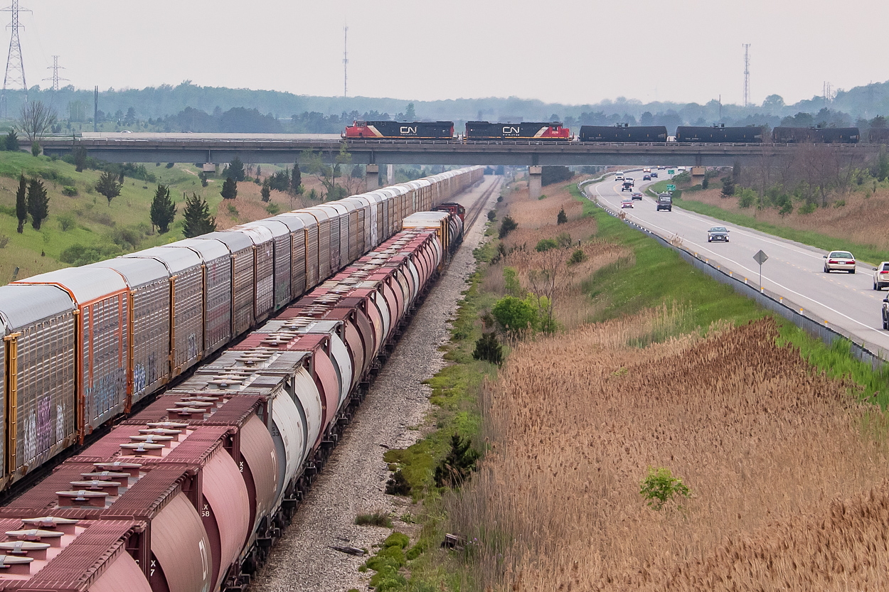 Heading away from the camera, on the CP Hamilton Sub, is CN L562 with a solo CN 5615 and 50+ cars headed for interchange with Trillium at Feeder. Of note are the 40 or so hoppers bringing up the rear - all old 3800 cubic foot CN hoppers on their final ride with CN, heading for scrap at SLM in Welland. Pictured at centre and crossing over top of 562 on the CN Stamford Sub is CN L531, heading for Fort Erie and onward to Buffalo. 2283 and 2006 were at the helm of 531. I was here waiting for 562 so I could document the demise of these hoppers, and I was up on Miller Road waiting for it to come off of the connecting track and onto the Hamilton Sub, when I heard 531 blowing for a nearby crossing and hoped I might be able to see an interesting meet of two CN trains - one on CP track and the other on CN. I admittedly did not have this shot in mind when I got to Miller, but am happy things fell into place.