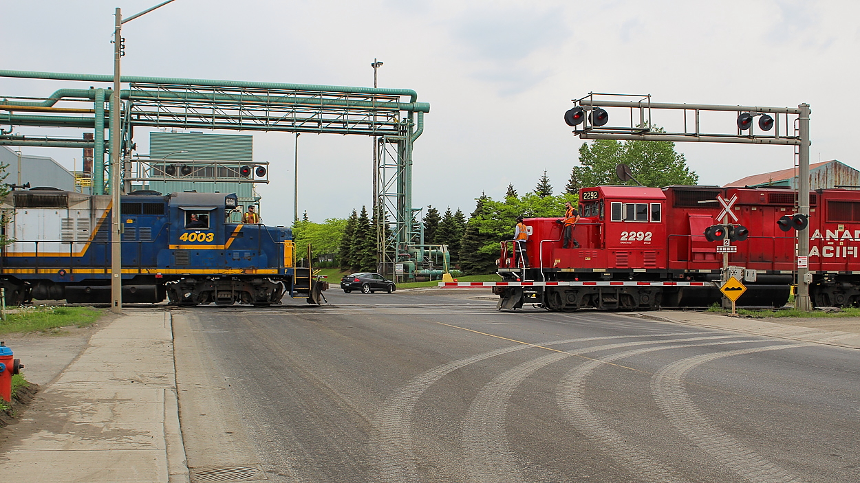 Well this was an interesting meet to see. Though it looks like the two trains will converge in the intersection, they are actually both eastbound. SOR is shoving, while CP is pulling ahead. Crews from both trains readying to throw switches. CP is presumably going to pull across Ottawa Street and shove back west to work the interchange. If you're going to get a CN-CP meet in industrial Hamilton, this is a pretty likely spot. I saw SOR and CP meet here a couple of times, and came within seconds of a meet shot with CN and CP earlier this month. Funnily enough, the arrival of the second train was evidently enough for the driver of the black car, pictured turning around to find an alternate route.