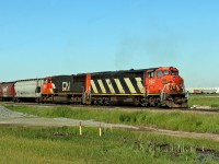 DASH 8-40Cm CN 2402 and SD75I CN 5683 ease around the curve as they approach Scotford Yard