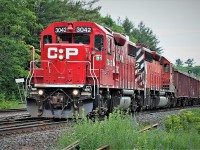A loaded southbound Canadian Pacific Herzog ballast train is diverging off the CN Bala Subdivision at Boyne Junction and getting back on home rails on Canadian Pacific's Parry Sound Subdivision at Reynolds. Powering the train is an all GMD-consist that included; GP38-2 3042 and SD40-2 6062.