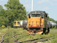 There was an abundance of yellow in an extremely weedy Kitchener yard as Goderich-Exeter Railway train 582 with LLPX 2236 sets-off cars while Waterloo Central Railway GE 70-Tonner 1556 is between assignments in the background.