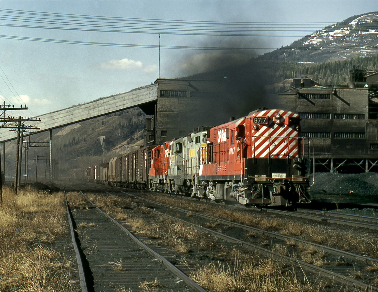 The eastbound Trail freight passes the Crowsnest Pass Coal Company's tipple and coking ovens at the base of the Crownest pass.