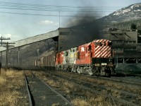 The eastbound Trail freight passes the Crowsnest Pass Coal Company's tipple and coking ovens at the base of the Crownest pass.