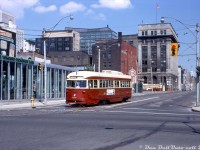 TTC PCC 4599 operates on a fantrip, making the turn from southbound on Church Street to westbound on Wellington. In the background, another TTC PCC can be seen heading eastbound on King Street. The downtown skyline in this part of town was a little less impressive back then than it is today. 4599 was part of a 52-car group of PCC's acquired secondhand from the Cincinnati Street Railway in 1950. Half were pre-war "air-operated" PCC's built by St. Louis Car in 1939/40, classified as TTC "A10" cars 4575-4601, and the other half were the <a href=http://www.railpictures.ca/?attachment_id=37799><b>A9 "all-electric" cars</b></a> 4550-4574 built in 1947). They operated in Toronto for nearly two decades until most of the A10's were included in part of a group of 100 Toronto PCC's sold to Egypt in 1968 (rendered surplus due to the opening of the Bloor-Danforth subway extensions, that replaced the <a href=http://www.railpictures.ca/?attachment_id=31201><b>Bloor and Danforth "shuttle" runs)</b></a>. Six of the remaining A10's were sold to Tampico, Mexico in 1971/72, including car 4599.<br><br>The Church/Wellington/Front intersection was at the south end of the old Church streetcar route (they used to loop Front-Scott-Wellington), which ran all the way up to Bloor ending at Asquith Loop. Regular streetcar service had ended in May 1954 (replaced by buses), but the tracks along the southern part of Church between College & Wellington were retained for short-turns and diversions, and remain in use for that purpose to this day.<br><br>Mid-century modern bank building at the north-west corner of Church & Wellington has served home to a Toronto Dominion Bank, a Pizza Pizza, and is currently a burger bistro.<br><br><i>Foster Morrison photo, Dan Dell'Unto collection slide</i>.