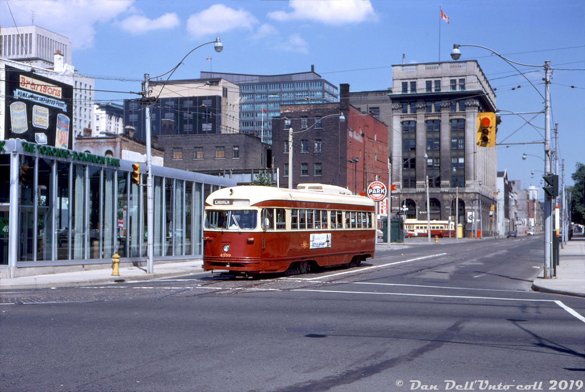 TTC PCC 4599 operates on a fantrip, making the turn from southbound on Church Street to westbound on Wellington. In the background, another TTC PCC can be seen heading eastbound on King Street. The downtown skyline in this part of town was a little less impressive back then than it is today. 4599 was part of a 52-car group of PCC's acquired secondhand from the Cincinnati Street Railway in 1950. Half were pre-war "air-operated" PCC's built by St. Louis Car in 1939/40, classified as TTC "A10" cars 4575-4601, and the other half were the A9 "all-electric" cars 4550-4574 built in 1947). They operated in Toronto for nearly two decades until most of the A10's were included in part of a group of 100 Toronto PCC's sold to Egypt in 1968 (rendered surplus due to the opening of the Bloor-Danforth subway extensions, that replaced the Bloor and Danforth "shuttle" runs). Six of the remaining A10's were sold to Tampico, Mexico in 1971/72, including car 4599.The Church/Wellington/Front intersection was at the south end of the old Church streetcar route (they used to loop Front-Scott-Wellington), which ran all the way up to Bloor ending at Asquith Loop. Regular streetcar service had ended in May 1954 (replaced by buses), but the tracks along the southern part of Church between College & Wellington were retained for short-turns and diversions, and remain in use for that purpose to this day.Mid-century modern bank building at the north-west corner of Church & Wellington has served home to a Toronto Dominion Bank, a Pizza Pizza, and is currently a burger bistro.Foster Morrison photo, Dan Dell'Unto collection slide.