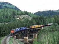 It was a cloudy May 19, 1986 west of Avola, British Columbia when Peter Jobe photographed CN 5289 and CR 6618 and CR 6619 crossing the North Thompson River. This was CN train #201.