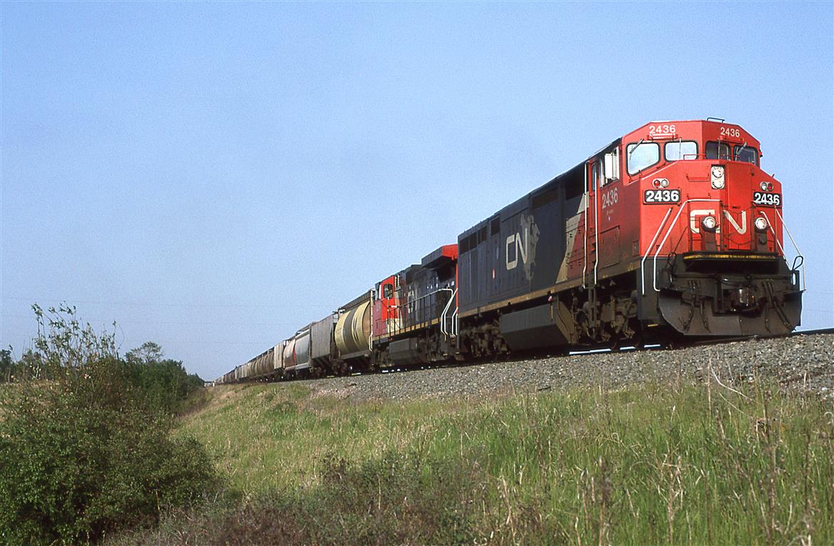 Not a particularly interesting photo location, but the locomotives might be otherwise....
An couple different generations of GE's team up to bring this empty grain train into Edmonton. Little did we know at the time that this was future.