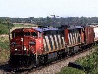 Still at Bremnar. The bank along the tracks here was just high enough to see over the train. 
I guess Bremnar does not exist anymore. It was a short siding that often stored cars for some reason. Someone at HQ probably decided that it was too costly to maintain.
Although we did hear the train designation, it was likely 759, the most common potash train seen by me.