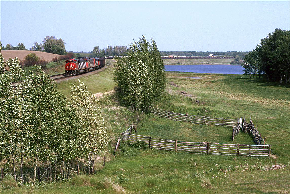 I was trying to get the "feeling" of railfanning Carvel with this shot. I had been looking at RR books and CTC Board magazine (Remember that?) and I noticed that the photos that most intrigued me were those that incorporated a sense of place. For those that know the area, did I succeed?
Oh, by the way, this is the coal train returning to the mines at Coal Valley (from Thunder Bay). The suspected phosphate train can be seen on the north track, over the coal gondolas.