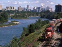 Probably, my favorite spot to train watch in Calgary, the east switch at Brickburn offered lots of possibilities for photos, with the semi-seclusion provided by the Bow River and the forested hill or the right. With this position, the city and river take a more prominent roll. In 1995, there were only a hand full of trains that carried containers exclusively. Higher priority cars were usually placed at the front of the train, presumably for quick access at the destination. Otherwise, there could be just about anything tacked onto the train to "fill it out".
The lead engine has entered the section of super elevated curvature. I am not sure why this existed. Even the "Canadian" came through here at a very modest speed.