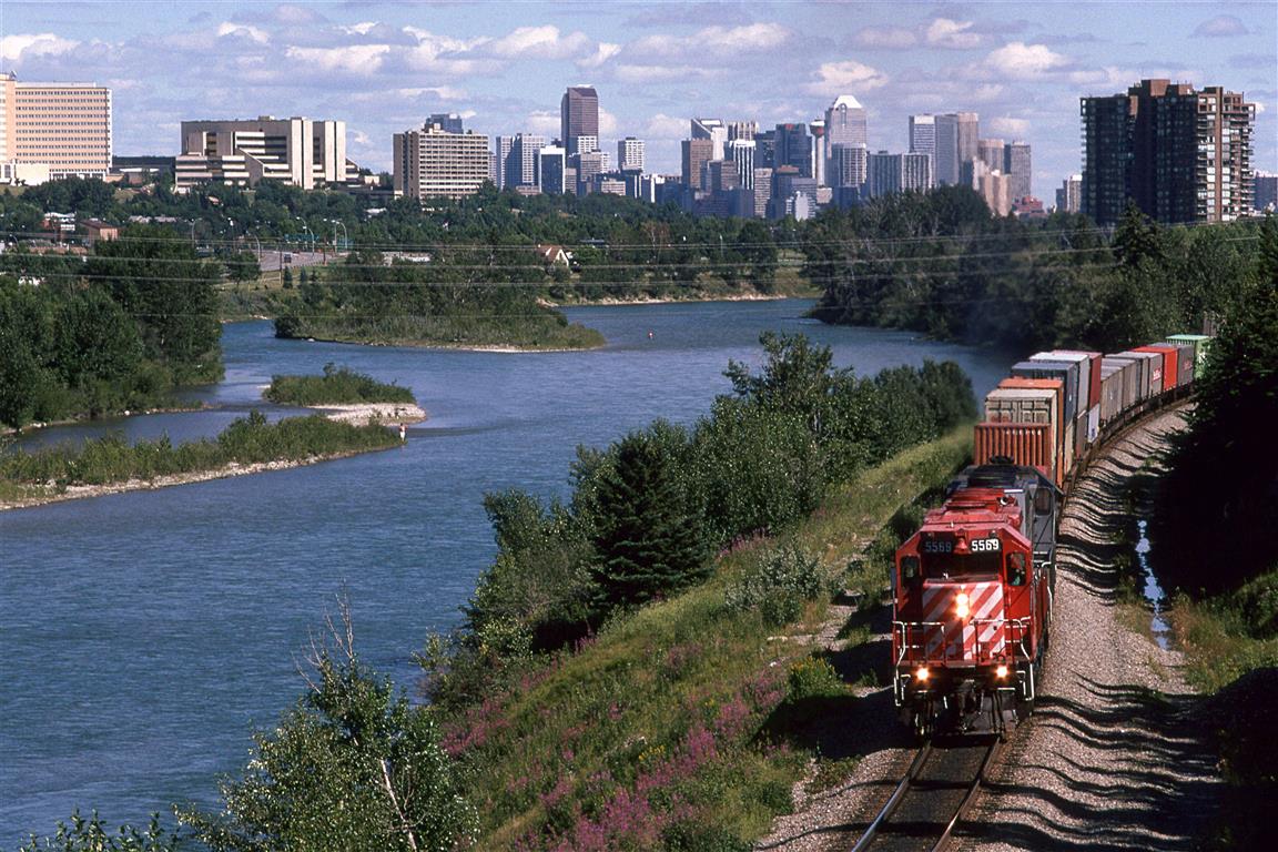Probably, my favorite spot to train watch in Calgary, the east switch at Brickburn offered lots of possibilities for photos, with the semi-seclusion provided by the Bow River and the forested hill or the right. With this position, the city and river take a more prominent roll. In 1995, there were only a hand full of trains that carried containers exclusively. Higher priority cars were usually placed at the front of the train, presumably for quick access at the destination. Otherwise, there could be just about anything tacked onto the train to "fill it out".
The lead engine has entered the section of super elevated curvature. I am not sure why this existed. Even the "Canadian" came through here at a very modest speed.
