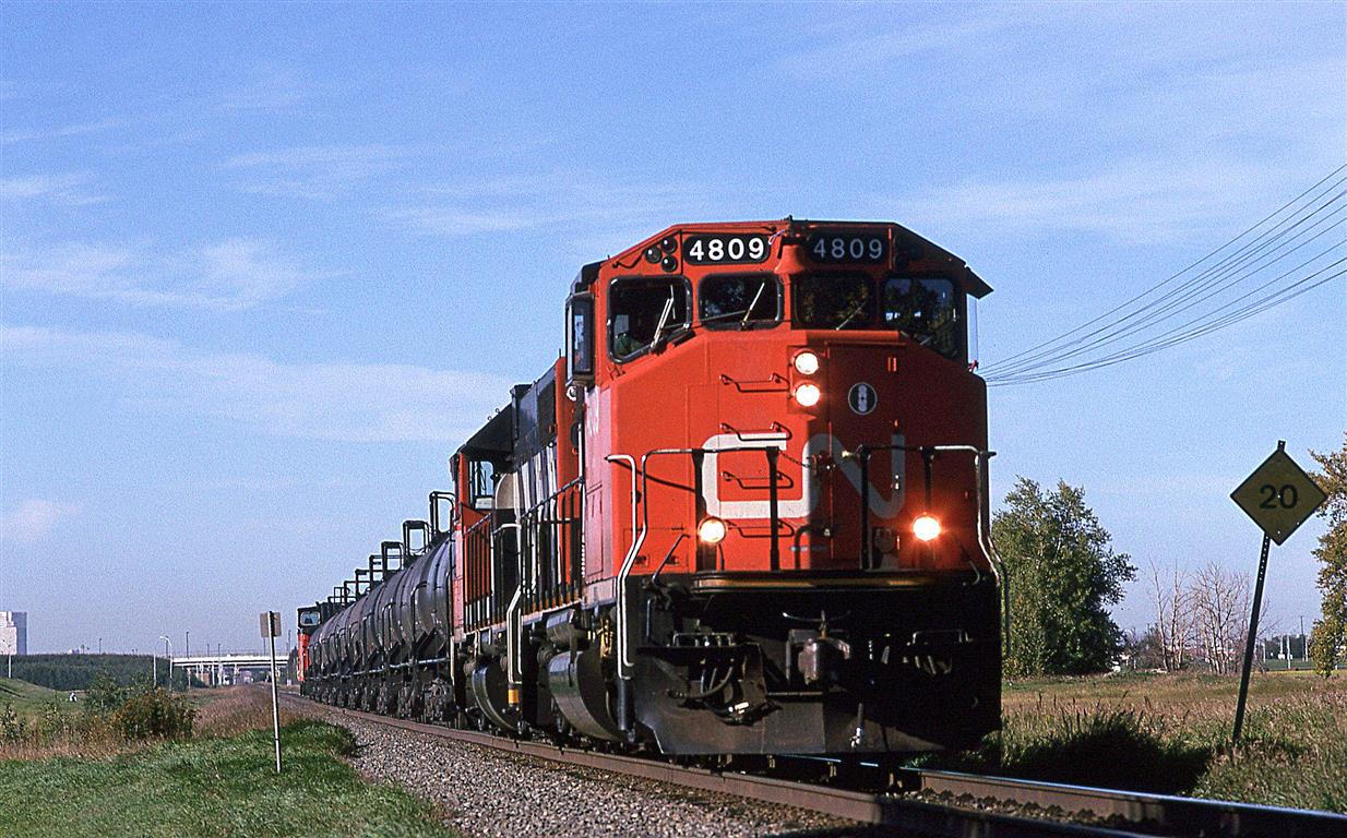 586 is eastbound on the Vegreville Sub for a brief time, before veering north on the Coronado Sub. At Abilene, it will take the Bonnyville Sub to Cold Lake (which the RR called Grand Centre). Cold Lake is the home of the Canadian Air Force base. Those tank cars in yow are full of aviation fuel, a very distinctive cargo that identifies the this train as 586. This train ran once, maybe twice a week.
If someone could help me out, I do not remember what that tall structure is at the extreme left, on the horizon.